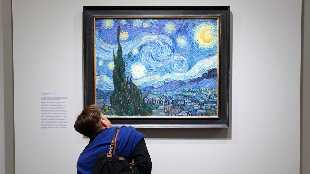 A person looks at Vincent van Gogh's "The Starry Night" during a press preview for Van Gogh's Cypresses at The Met Fifth Avenue in New York on May 15, 2023. Featuring some 40 works by Vincent van Gogh (18531890), this exhibition is the first to focus on the unique vision the artist brought to bear on the cypresses. (Photo by TIMOTHY A. CLARY / AFP) / RESTRICTED TO EDITORIAL USE - MANDATORY MENTION OF THE ARTIST UPON PUBLICATION - TO ILLUSTRATE THE EVENT AS SPECIFIED IN THE CAPTION (Photo by TIMOTHY A. CLARY/AFP via Getty Images)