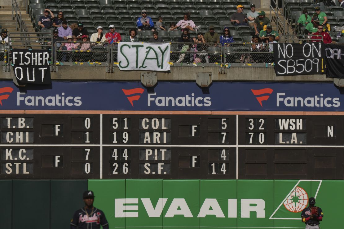 Fans sit behind signs referencing plans for the Oakland Athletics to move to Las Vegas during a game against the Atlanta Braves at RingCentral Coliseum on May 29, 2023.