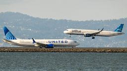 A United Airlines plane prepares for takeoff as a JetBlue plane lands at San Francisco International Airport in 2023.