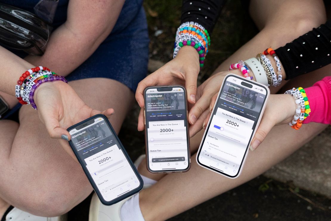 (From left) Anna Mason, Emily Lind, and Kristen Robinson show their Eras Tour Ticketmaster queue while in the parking lot outside of the Taylor Swift concert at Lincoln Financial Field in Philadelphia in May 2023.