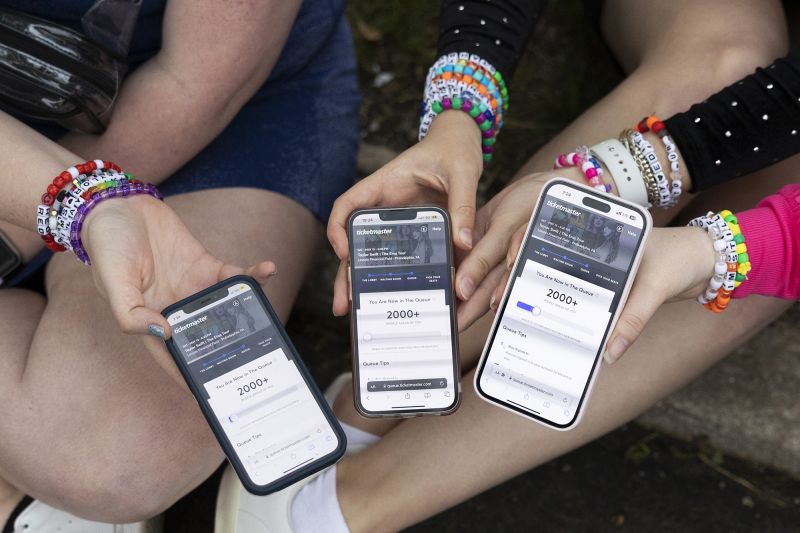 (From left) Anna Mason, Emily Lind, and Kristen Robinson show their Ticketmaster queue, which displays over 2000+ people ahead of them, from the parking lot outside of the Taylor Swift concert at Lincoln Financial Field in Philadelphia, Pennsylvania on May 13, 2023. The friends drove up to Philadelphia from Washington D.C. in the hopes that they could find last minute tickets to the show.