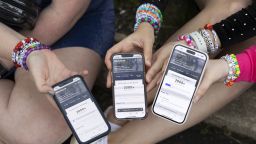 (From left) Anna Mason, Emily Lind, and Kristen Robinson show their Ticketmaster queue, which displays over 2000+ people ahead of them, from the parking lot outside of the Taylor Swift concert at Lincoln Financial Field in Philadelphia, Pennsylvania on May 13, 2023. The friends drove up to Philadelphia from Washington D.C. in the hopes that they could find last minute tickets to the show.