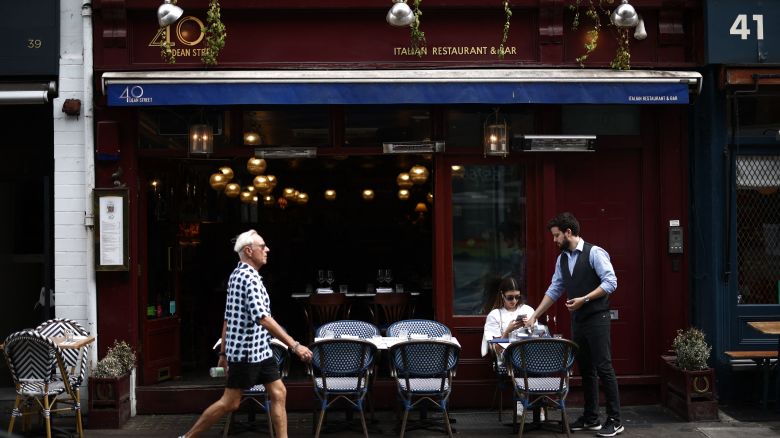 A customer is served outside an Italian restaurant in the Soho area of London on June 18, 2023. Recent data showed UK inflation slowed to a 13-month low in April, but remains elevated at 8.7 percent as soaring food prices offset weaker energy costs. (Photo by HENRY NICHOLLS / AFP) (Photo by HENRY NICHOLLS/AFP via Getty Images)