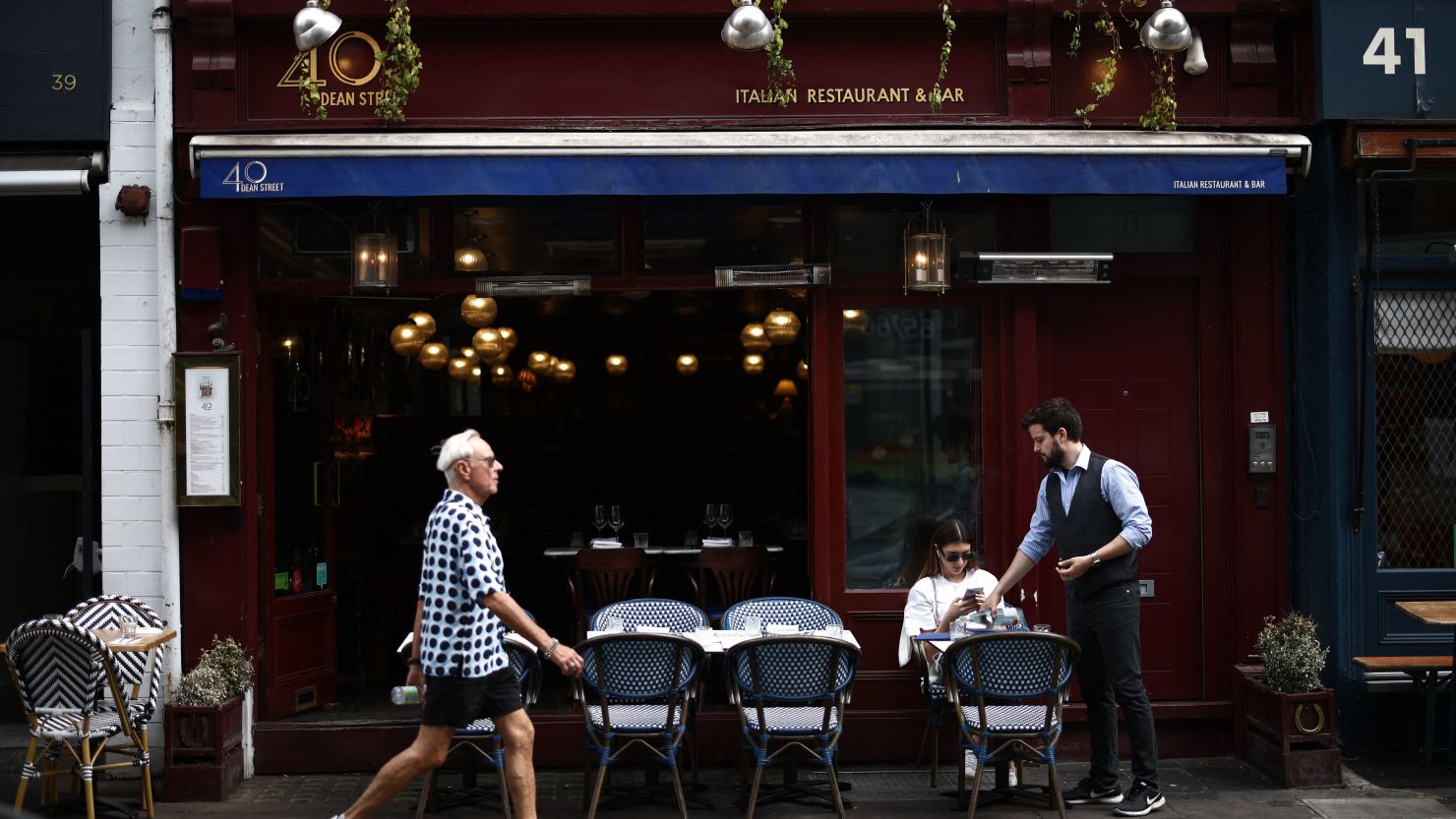 A customer is served at 40 Dean Street, an Italian restaurant in London's Soho area, in June 2023.