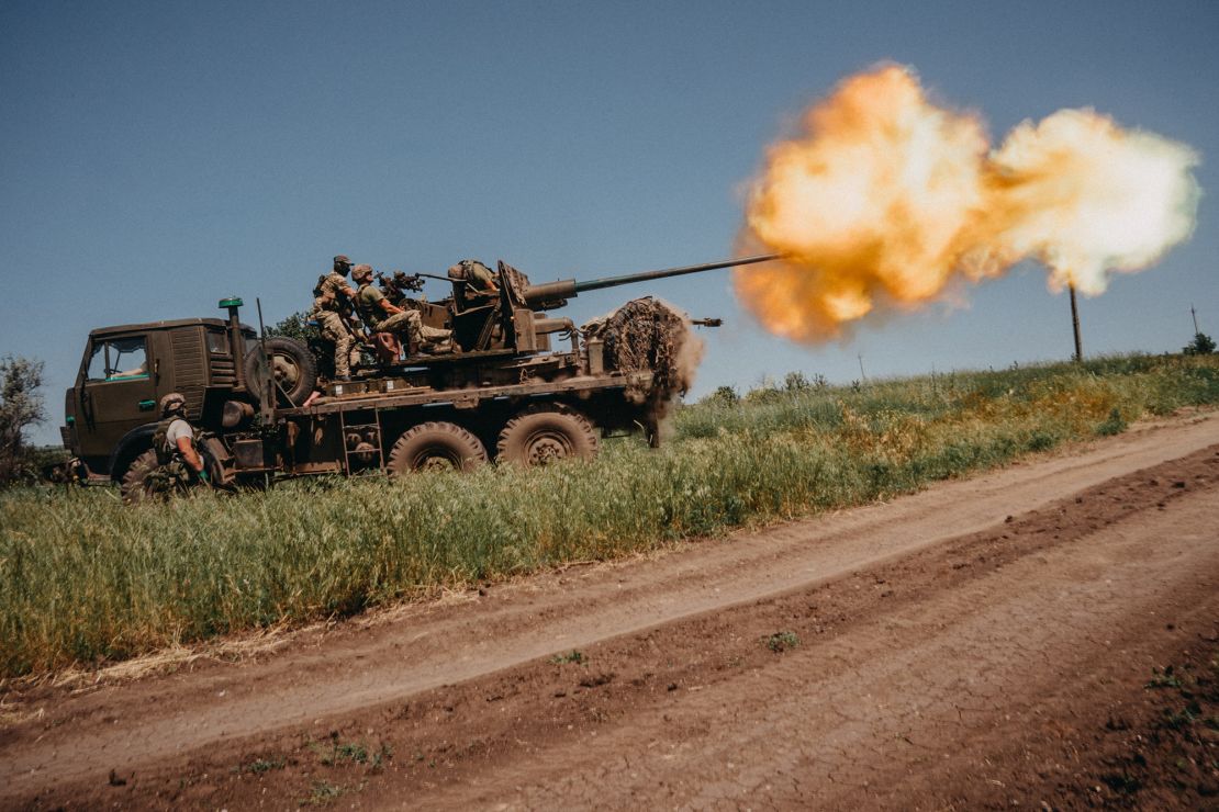 Ukrainian soldiers shoot rounds into Russian positions with an S60 anti-aircraft canon placed on a truck, outside Bakhmut.