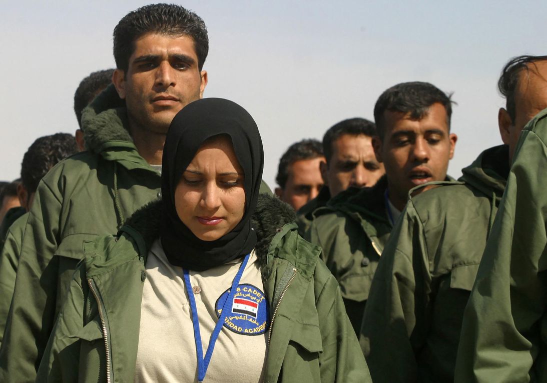 An Iraqi policewoman marches among male colleagues as they train at Baghdad's Police Academy in the Iraqi capital on February 24, 2004.