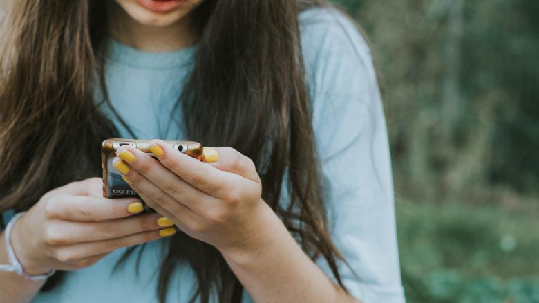 Teen girl with yellow nail polish. Unrecognizable person.
