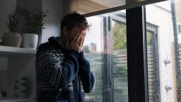 Man by window - head in hands