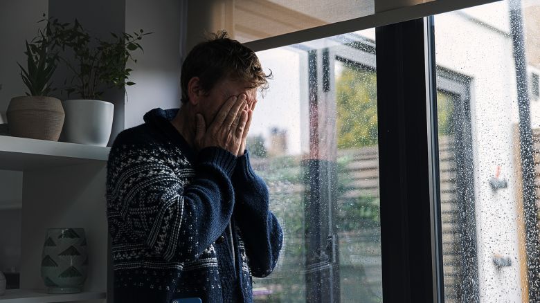 Man by window - head in hands