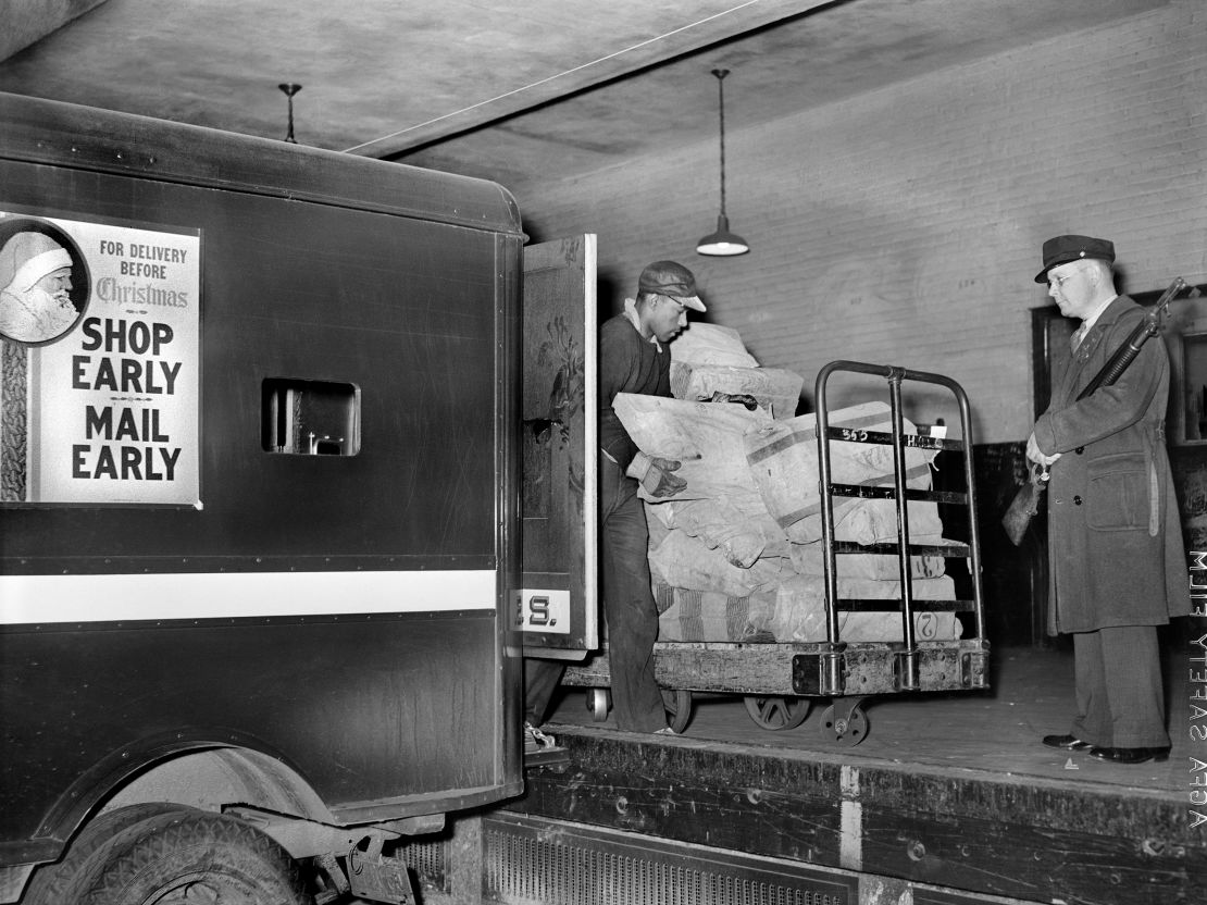 Trabajadores en la plataforma de carga colocando correo en camiones en 1938.