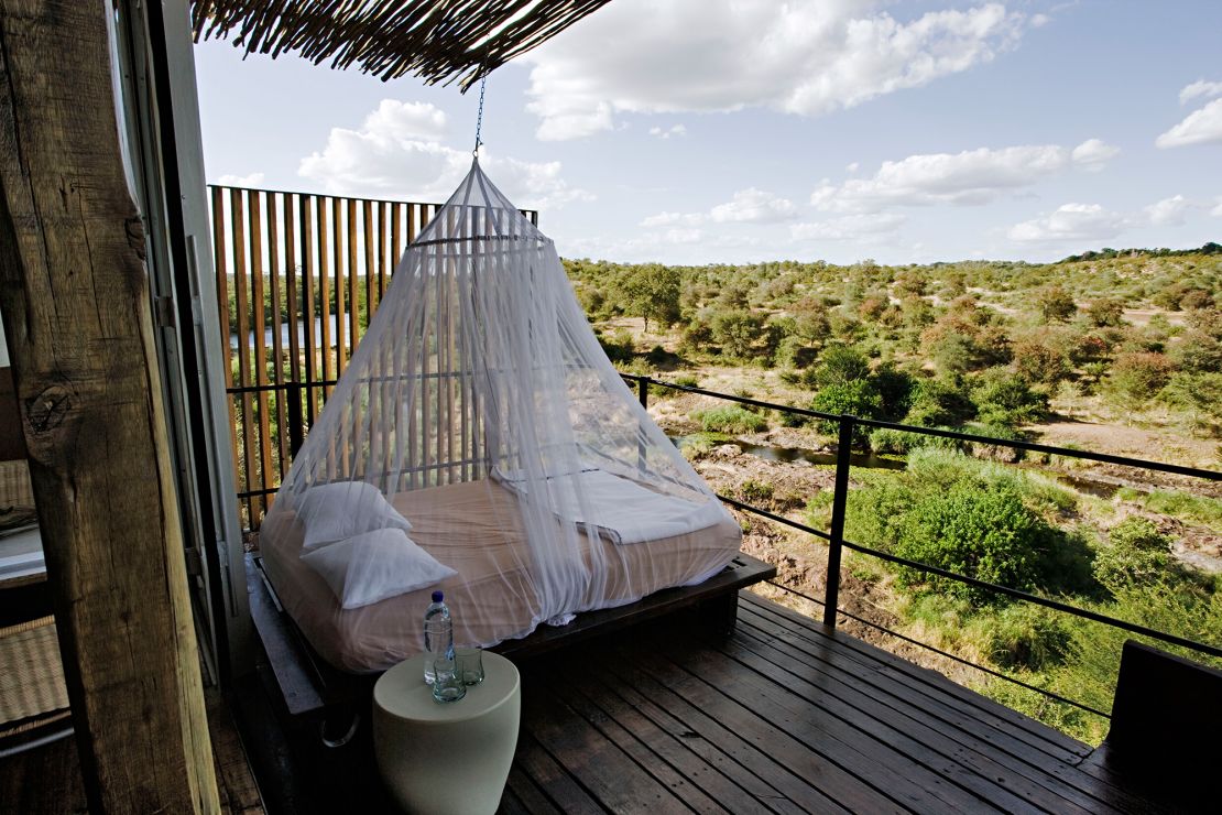 A mosquito net hangs above a daybed on the observation deck of a luxury clifftop suite in South Africa.