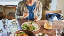 The woman are eating vegan food, taco rice. 
The straw is a stainless steel reusable straw.
 In the foreground is a Buddha bowl.