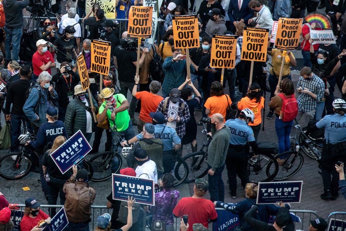 Police officers stand between supporters and opponents of Donald Trump outside the Philadelphia Convention Center on November 6, 2020, as the counting of ballots continues in Pennsylvania.