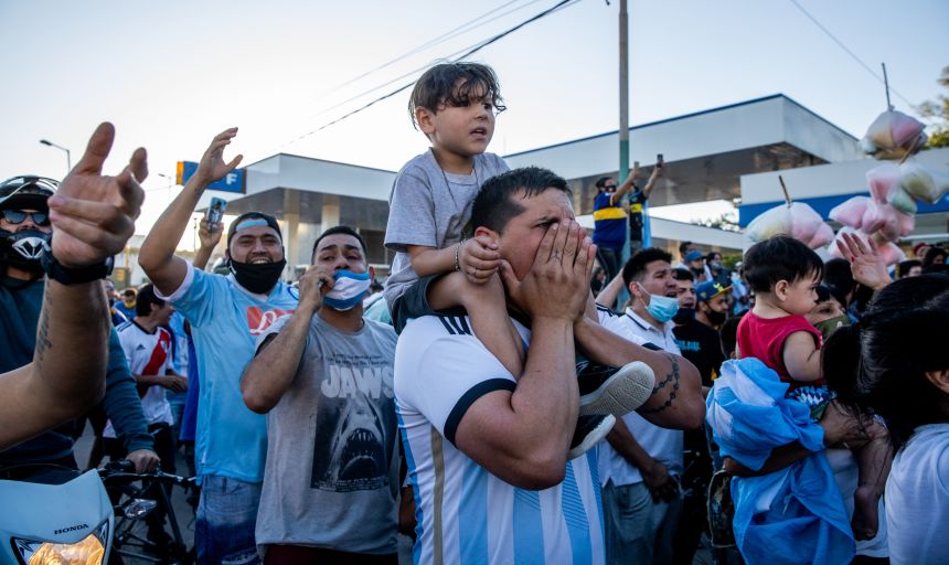 Fans cheer and pay tribute during the burial ceremony of Argentine football legend Diego Maradona in November 2020.