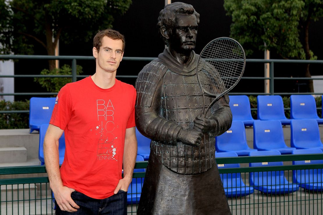 Andy Murray poses next to his terracotta sculpture.