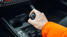 Man's hand switches manual transmission closeup