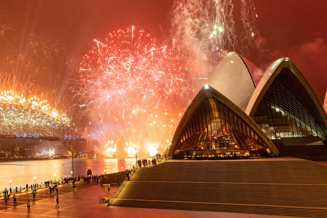 The Sydney Opera House, a masterpiece of 20th-century architecture, is illuminated by bursts of fireworks.