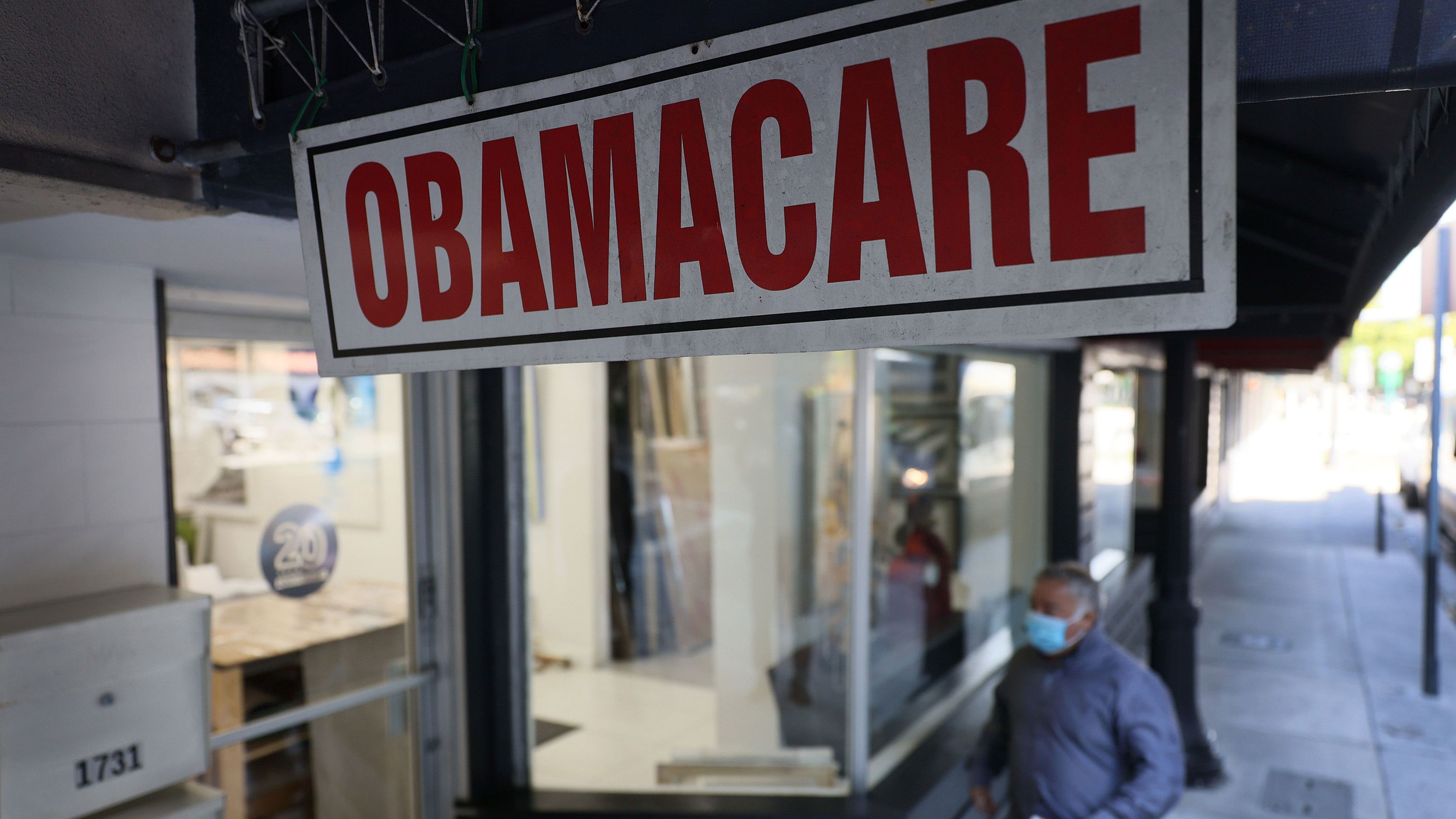 A pedestrian walks past the Leading Insurance Agency, which offers plans under the Affordable Care Act (also known as Obamacare) on January 28, 2021, in Miami, Florida.