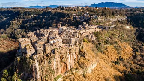 Aerial view of the medieval village of Calcata with its volcanic cliff and the valley of the Treja river with Mount Soratte in the background.