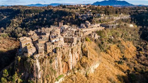 Aerial view of the medieval village of Calcata with its volcanic cliff and the valley of the Treja river with Mount Soratte in the background.