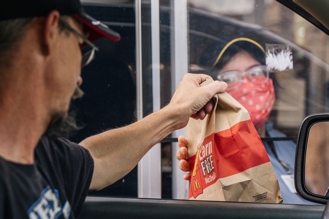 A customer receives his food in a McDonald's drive-thru on July 28, 2021 in Houston, Texas.