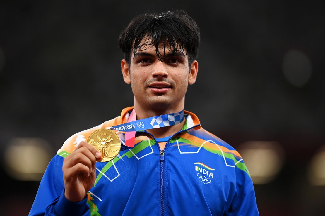 Chopra stands on the podium with his gold medal at the Tokyo Olympics.