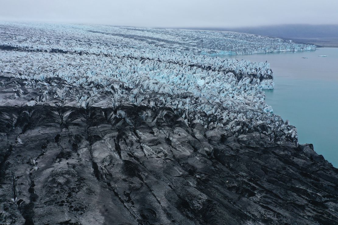 The receding Breiðamerkurjökull glacier, a portion of it black with volcanic dust and stones, ends at Jokulsarlon lake on August 15, 2021 near Hof, Iceland.