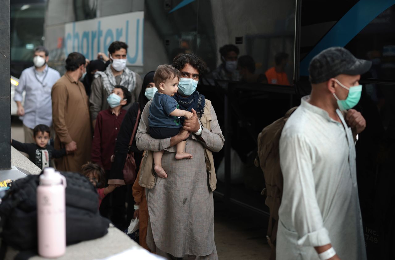 DULLES, VIRGINIA - AUGUST 31: Refugees board a bus at Dulles International Airport that will take them to a refugee processing center after being evacuated from Kabul following the Taliban takeover of Afghanistan on August 31, 2021 in Dulles, Virginia. The Department of Defense announced yesterday that the U.S. military had completed its withdrawal from Afghanistan, ending 20 years of war. (Photo by Anna Moneymaker/Getty Images)