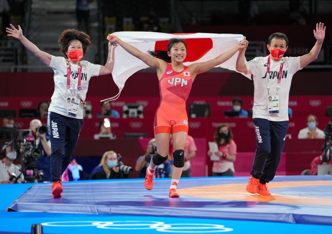 Yui Susaki celebrates with her coaches after winning gold in the Women's Freestyle 50kg final at the Tokyo 2020 Olympics.