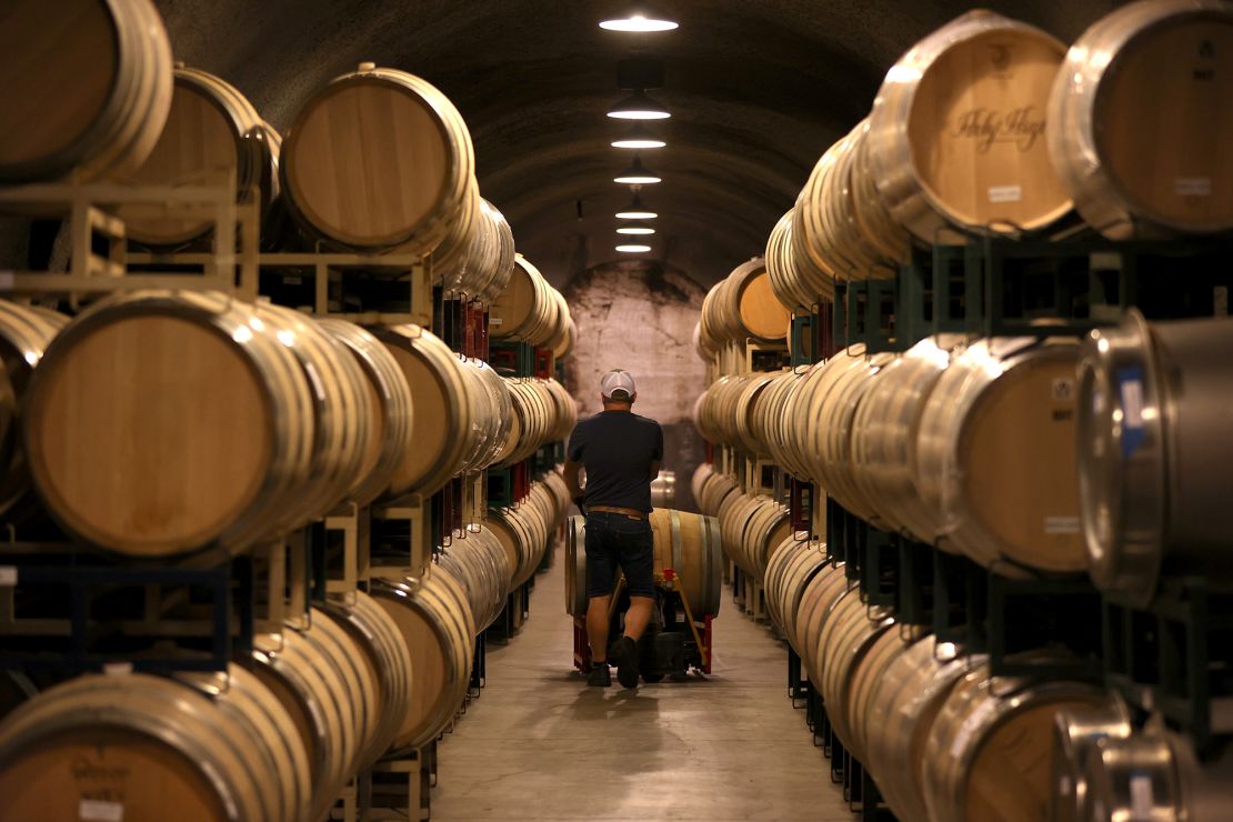 A worker pushes a wine barrel into a storage facility at Hunnicutt Wine Co. in St. Helena, California.