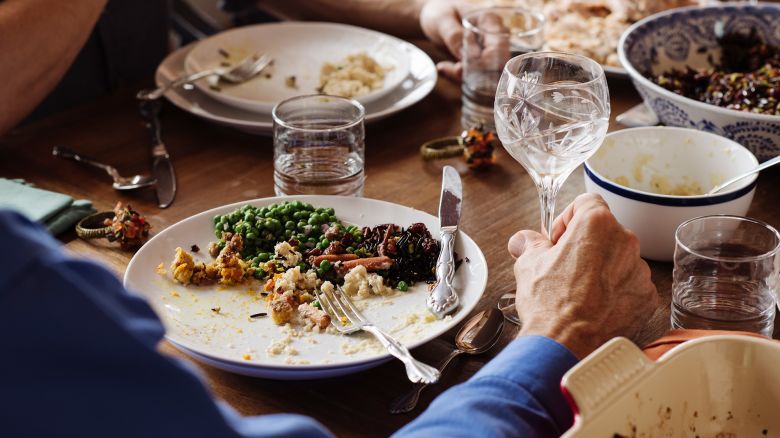 Senior man sitting with food and wineglass at dining table