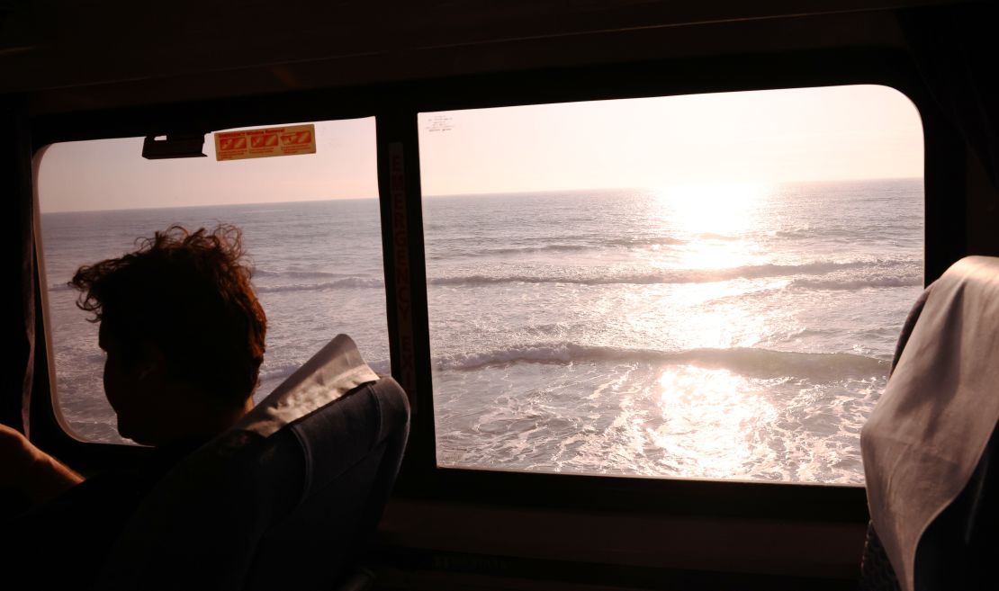 A passenger rides an Amtrak train passing near the Pacific Ocean on November 9, 2021 near Oceanside, California.