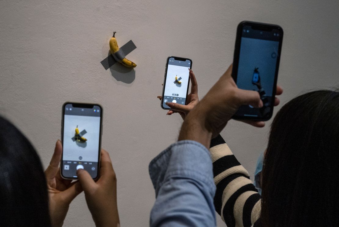 Visitors take pictures of Maurizio Cattelan's "Comedian" at the UCCA Center for Contemporary Art in Beijing, China on November 28, 2021.