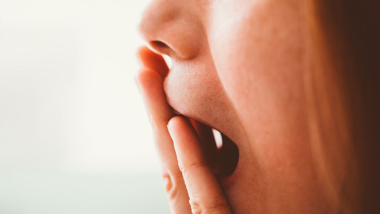 Cropped shot of a woman covering her mouth with her hand - Worried, emotional stress, not speaking, keeping silent, censorship, yawning, sleepy
