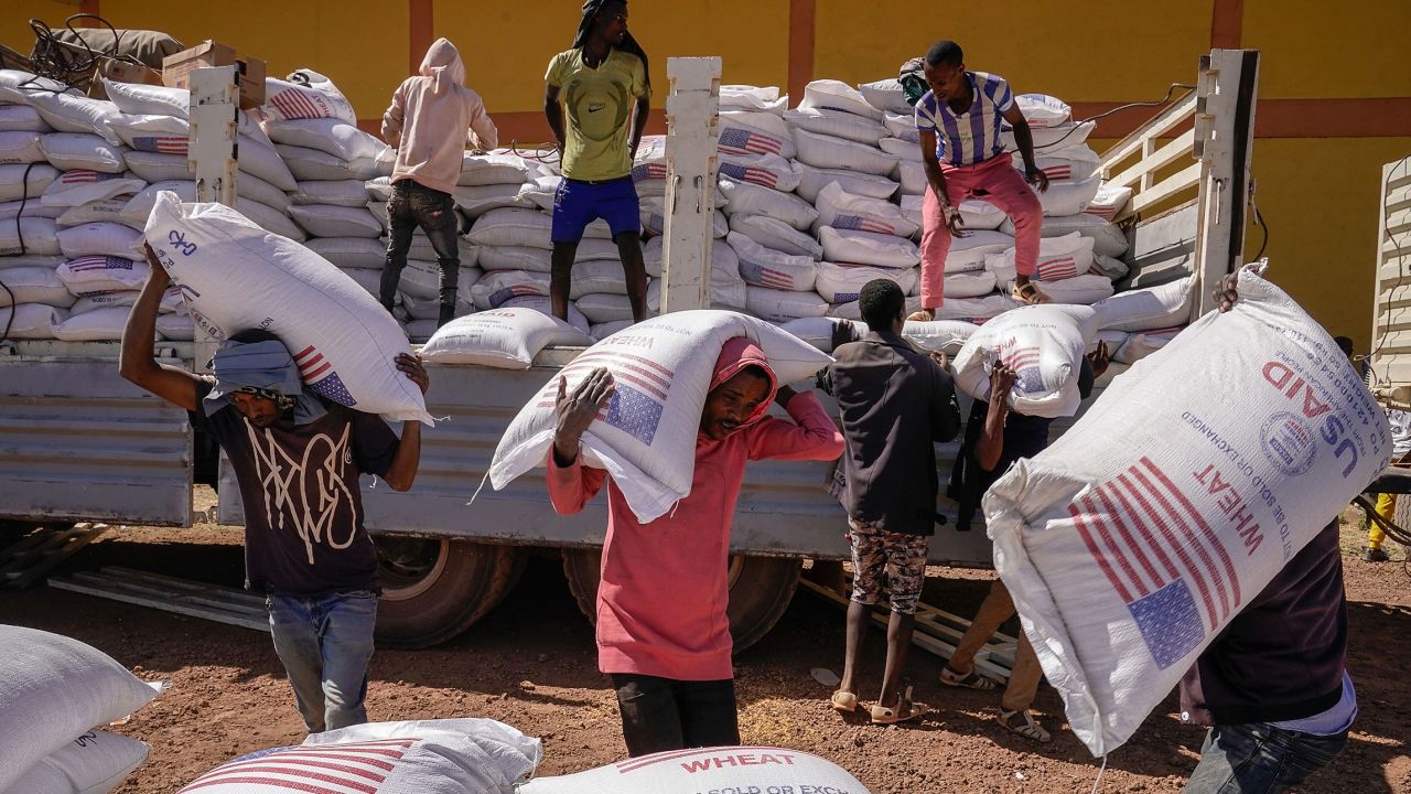 In this 2021 photo, volunteers at the Zanzalima Camp for Internally Displaced People unload 50 kilogram sacks of wheat flour that were a part of an aid delivery from USAID in Bahir Dar, Ethiopia.