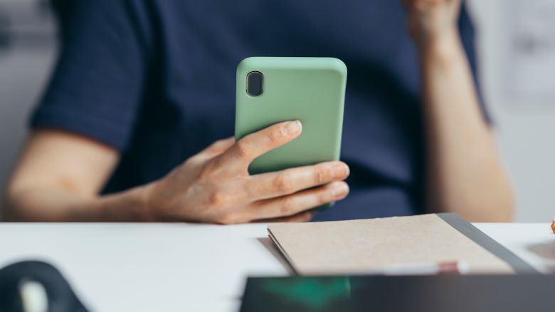 An unrecognizable person enjoying spending time on the mobile phone.
