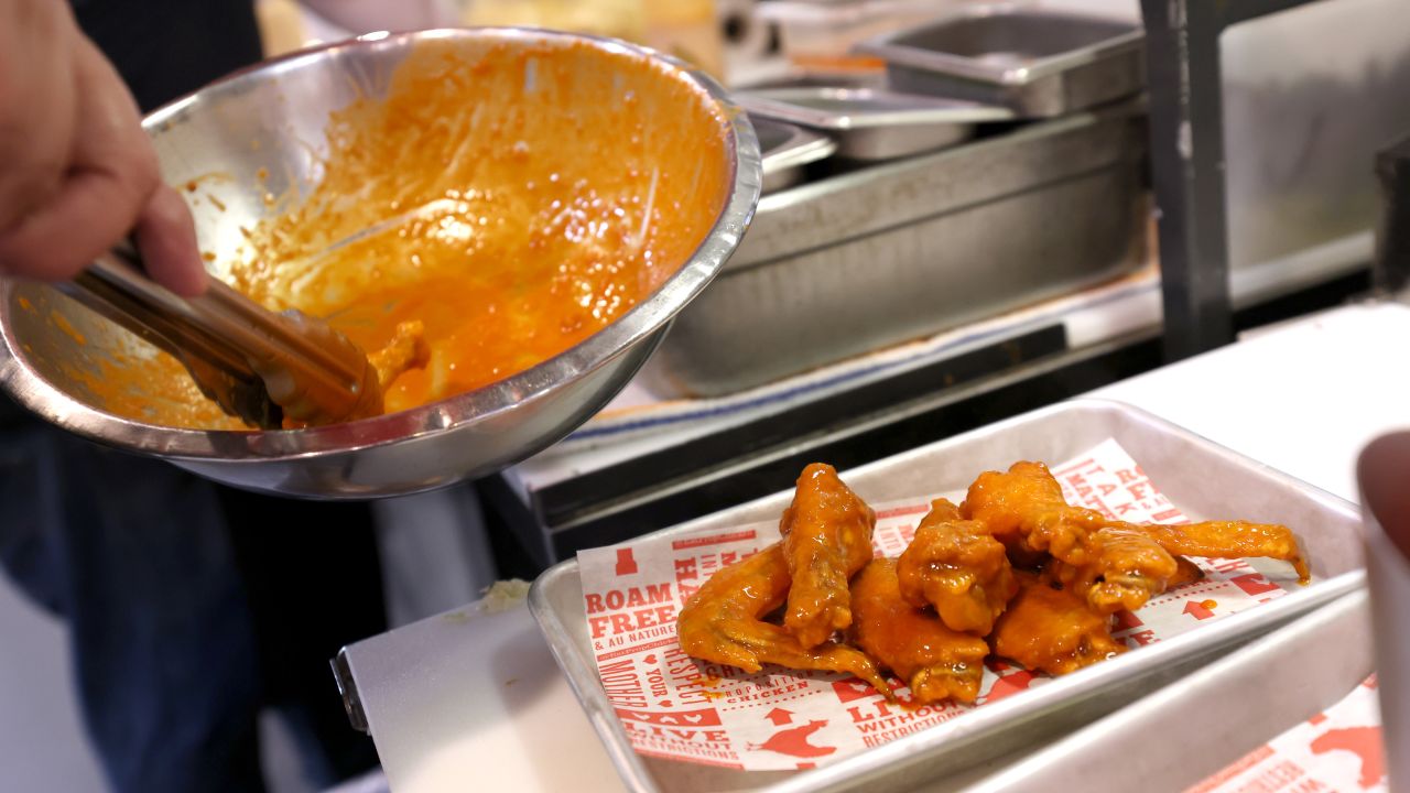 SAN FRANCISCO, CALIFORNIA - FEBRUARY 11: A cook at Proposition Chicken prepares Buffalo chicken wings on February 11, 2022 in San Francisco, California. Food supply chain issues are creating a shortage of chicken and chicken wings resulting in higher prices for the popular Super Bowl party snack. The retail price of chicken wings is up $0.30 since last year. (Photo by Justin Sullivan/Getty Images)