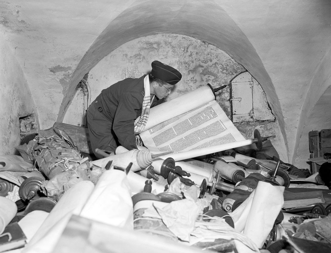 US Army Chaplain Samuel Blinder examines one of hundreds of looted sacred Torah scrolls on July 6, 1945.