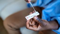 Young African American man taking a Self-swabbing home tests for COVID-19 at home with Antigen kit. Introducing nasal stick to check the infection of Coronavirus. Quarantine, pandemic.