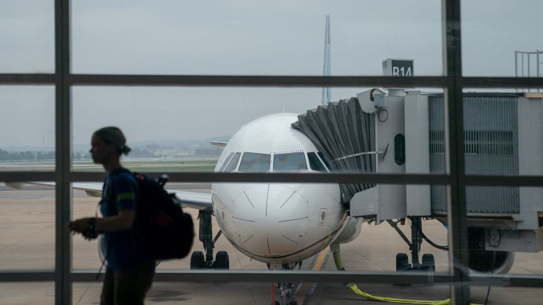 A traveler walks past a United Airlines aircraft, ahead of the July 4th holiday, at Ronald Reagan Washington National Airport in Arlington, Virginia, on July 1, 2023.