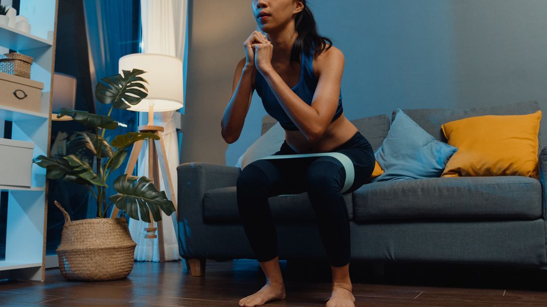 Chair squats target the quadriceps, hamstrings and glutes. Adding a resistance band above the tops of your knees can help you maintain form.