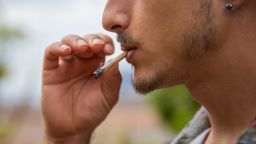 Close-Up Portrait of a man who smokes a joint of marijuana