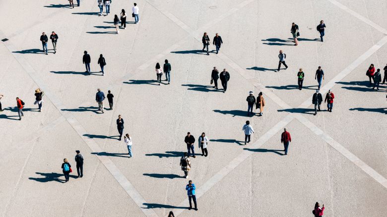 Aerial view of large number of people walking on the city square on the sunny day - stock photo