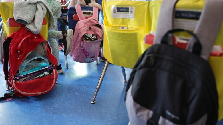 In this June 2022 photo, student backpacks hang on the backs of classroom chairs at a school in New York.