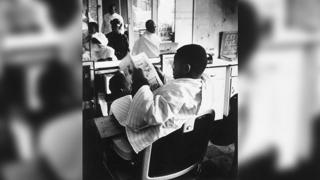 A young barbershop customer is seen in New York City's Harlem neighborhood, February 1956.