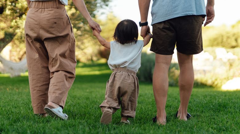 Cropped shot of young Asian family having fun in tourist resort with sunlight. Family vacation. Happy family portrait.