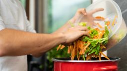 Young man making vegetable soup, broth, out of vegetable scraps