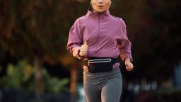 Young Asian sportswoman running while exercising in the park. Copy space.