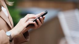 Close Up Mid Adult Female Freelancer's Hands Using Phone Outdoor. Selective Focus, Beige Colors, Ambient Light