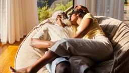 Loving couple kissing while lying face to face on a large bean bag chair at home together